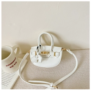 Détail du mini sac blanc grainé avec fermoir doré et pendentifs en forme d'étoile