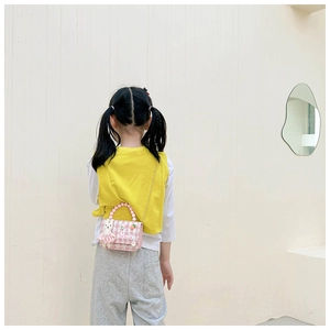 Détail du sac à main rose à carreaux pour enfant avec anse en perles et breloque lapin