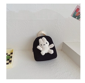 Detail of black canvas toddler backpack with a cute white plush rabbit doll attachment