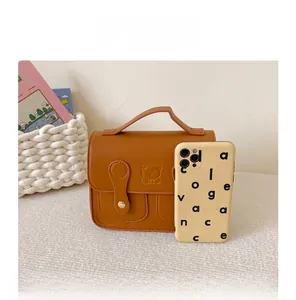 Close-up of mini brown PU leather bear backpack with flap lid and top handle detail