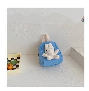 Detailed close-up of blue canvas toddler backpack with a 3D plush bunny and zipper detail