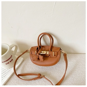 Détail d'un mini sac bandoulière en cuir marron avec boucle dorée et étoiles