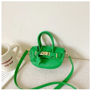 Détail du mini sac bandoulière en cuir PU vert avec fermoir rotatif et texture grainée