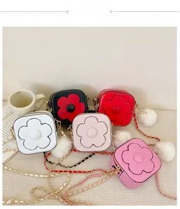 Vue détaillée des mini sacs colorés avec motifs de fleurs 3D et pompon doux
