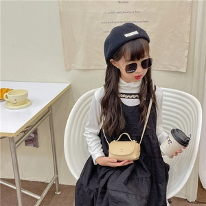 Girl's beige mini crossbody bag and vintage fashion outfit displayed in a lifestyle setting
