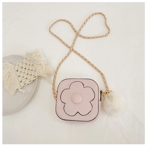 Détail d'un petit sac rose pour fille avec fleur en relief, chaîne dorée et pompon blanc