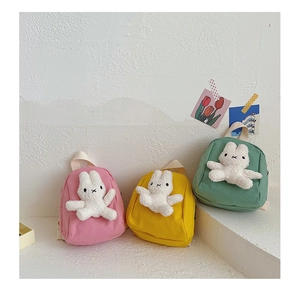 Detailed close-up of colorful canvas mini backpacks with cute 3D plush bunny dolls