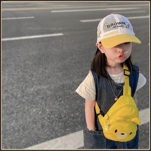 Détail d'un sac de poitrine ours jaune et d'une casquette en maille pour enfant
