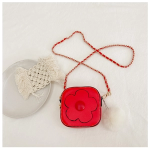 Détail du mini sac à bandoulière fleur rouge avec chaîne dorée et pompon en peluche