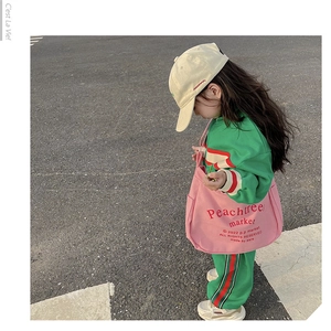 Detail showing a pink canvas tote bag with letter print and large capacity for kids