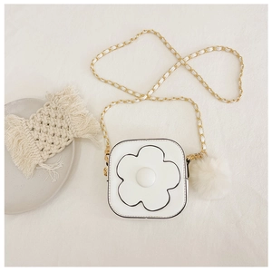 Détail de sac bandoulière blanc pour fille avec fleur, chaîne dorée et pompon en peluche
