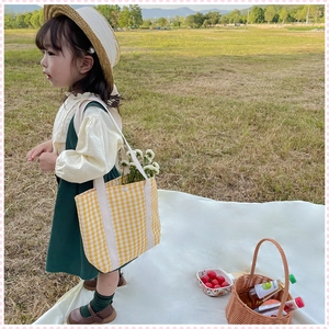 Detail of yellow and white checkered canvas tote bag for kids with snap closure