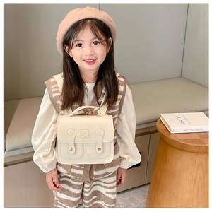 Toddler cream mini backpack with embossed bear detail shown on model back