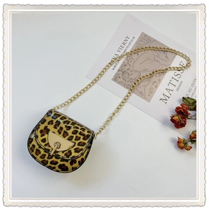 Close-up of leopard print girls' mini saddle bag with golden clasp and chain strap