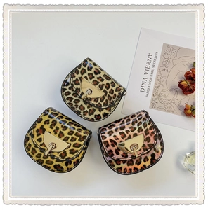 Detailed view of leopard print mini saddle bags in glossy patent leather with gold clasps