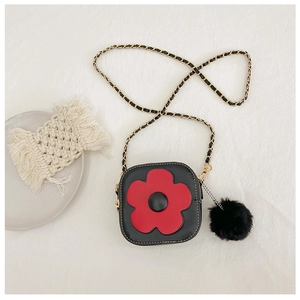Détail du sac à bandoulière noir pour fille avec fleur rouge et pompon en peluche