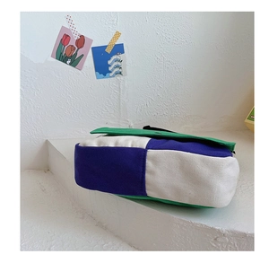 Détail du sac en toile tricolore montrant la texture épaisse et le soufflet latéral
