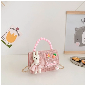 Détail d'un sac en tweed rose pour fille avec lapin 3D, poignée en perles et chaîne d'or