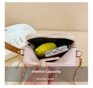 Detail view of pink quilted mini bag interior with gold chain strap and accessories