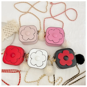 Détail de sacs à bandoulière fleuris colorés avec pompons doux et bandoulières en chaîne