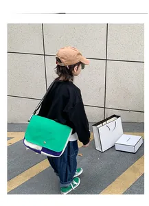 Photo en extérieur d'un enfant portant le sac messager tendance en toile color-block