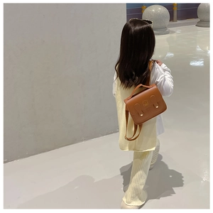 Close-up of brown PU leather kids backpack featuring an embossed teddy bear design