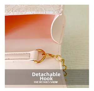 Detail of the detachable golden metal hook and pink leather strap on a girl shoulder bag