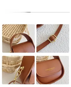 Detail view of brown leather girl's handbag with adjustable strap and metal hooks