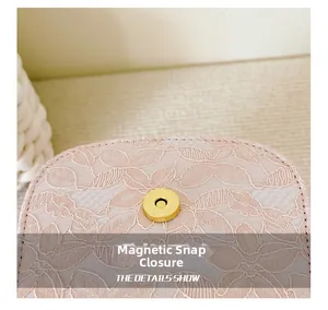 Detail of pink floral lace fabric and golden magnetic snap closure on a girl's handbag