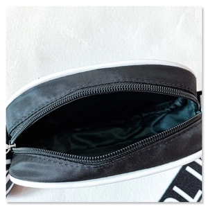 Detail view of the nylon bag interior showing smooth zipper and letter print strap