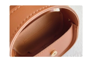 Detailed macro view of brown leather girl's mini handbag with golden magnetic clasp