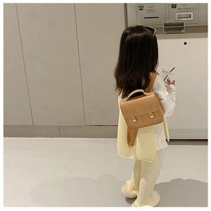 Rear view of a child wearing the vintage brown bear mini backpack with metal buckle