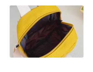 Detail view of the yellow canvas kids backpack showing the open main zipper compartment