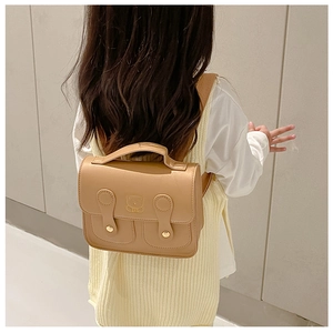 Kid wearing khaki PU leather bear backpack featuring buckle closures and embossed detail