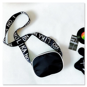 Detail of trendy nylon kids crossbody bag with adjustable lettered strap and white piping