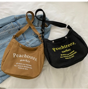 Detailed view of canvas crossbody bags in brown and black colors with letter prints