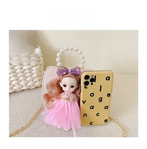 Mini pink lace bag with pearl handle and doll next to a phone for size reference