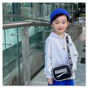Detail of kids black letter crossbody bag with printed strap and matching beanies