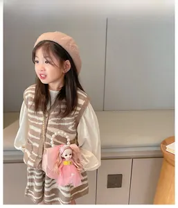 Girl wearing casual stripe vest, beige beret, and a mini doll crossbody bag with pearls
