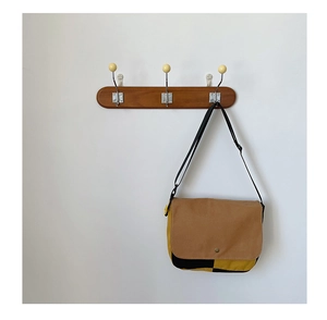 Détail du sac bandoulière en toile bicolore pour enfant avec bouton pression en métal