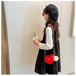 Girl's red heart-shaped crossbody bag with quilted leather texture and gold chain strap