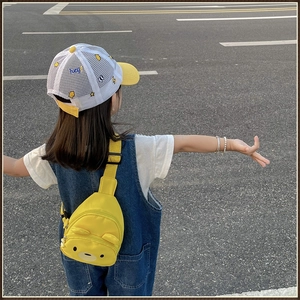 Détail d'un sac bandoulière en toile d'ours jaune porté avec une robe en jean pour enfant
