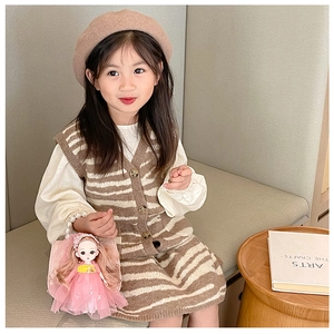 Detailed view of pink plush doll handbag with pearl handle on a child fashion outfit