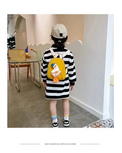 Detail shot of a yellow canvas toddler backpack with a 3D duck doll and blue cap