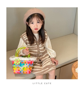 Detail of colorful woven kids tote bag with faux fur trim and floral charm decoration