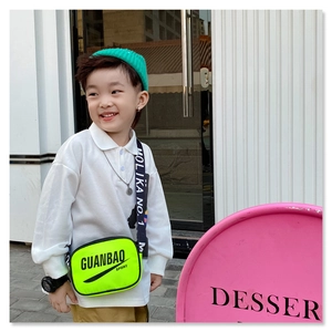 Detail of neon yellow kids sports crossbody bag with lettered strap and logo