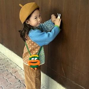 Sac bandoulière enfant tricoté avec visage drôle et lèvres orange sur laine verte