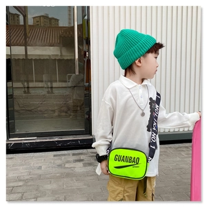 Detail of neon green kids crossbody bag with black adjustable strap and sport graphics