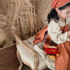 Robe chasuble orange enfant avec chemisier beige et petit sac monstre en crochet