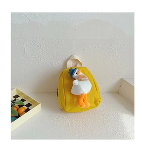 Close-up of a yellow canvas toddler backpack with a cute 3D plush duck decoration